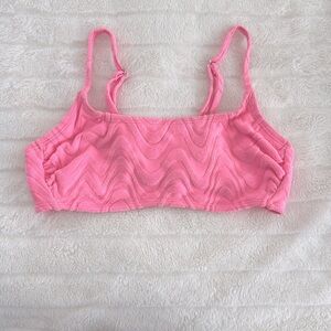 cute soft swimsuit top that is pink with wavy details on it. (xs)